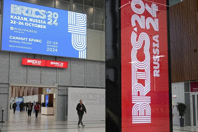 当地时间2024年10月21日，俄罗斯喀山，在金砖国家峰会举行的前一天，人们经过会场。视觉中国 图