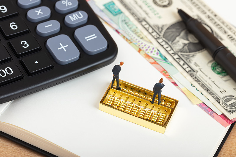 记账本计算器上思考金融经济的西装男图片下载