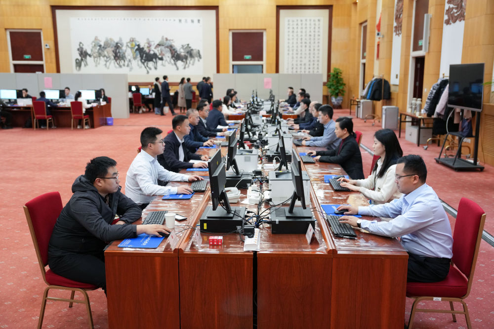 2025年3月9日，十四届全国人大三次会议秘书处工作人员在认真工作。新华社记者 郑焕松 摄